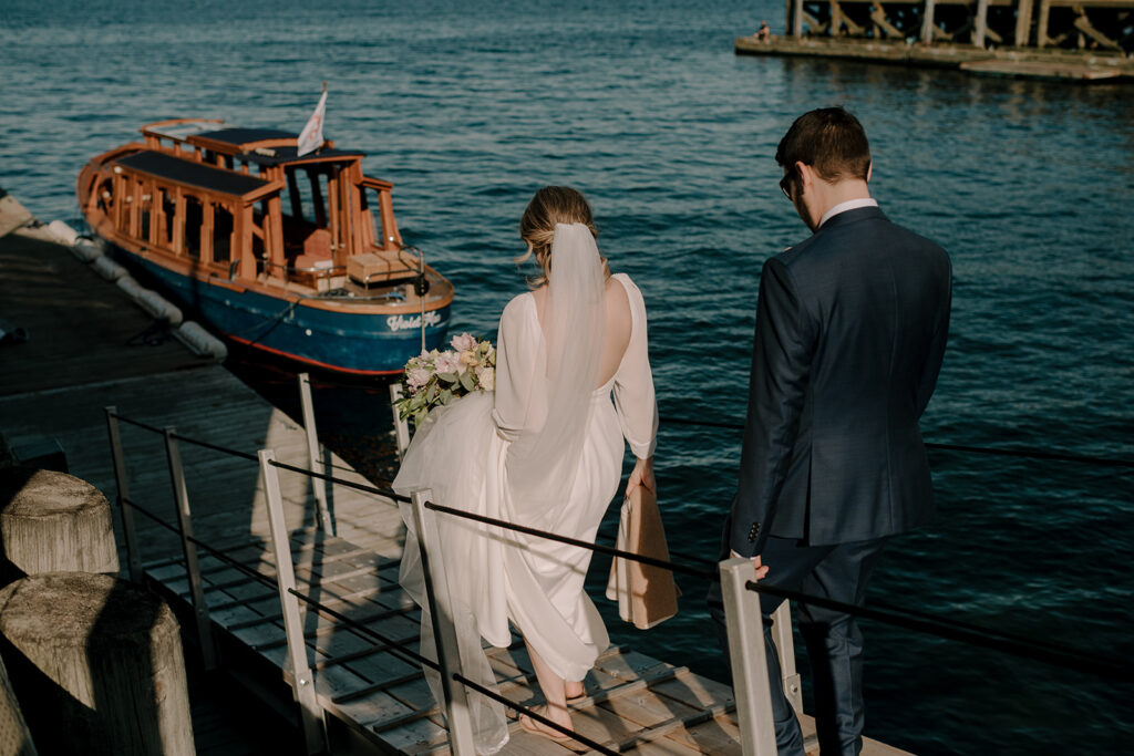Wedding couple walking down dock towards boat in Halifax Harbour