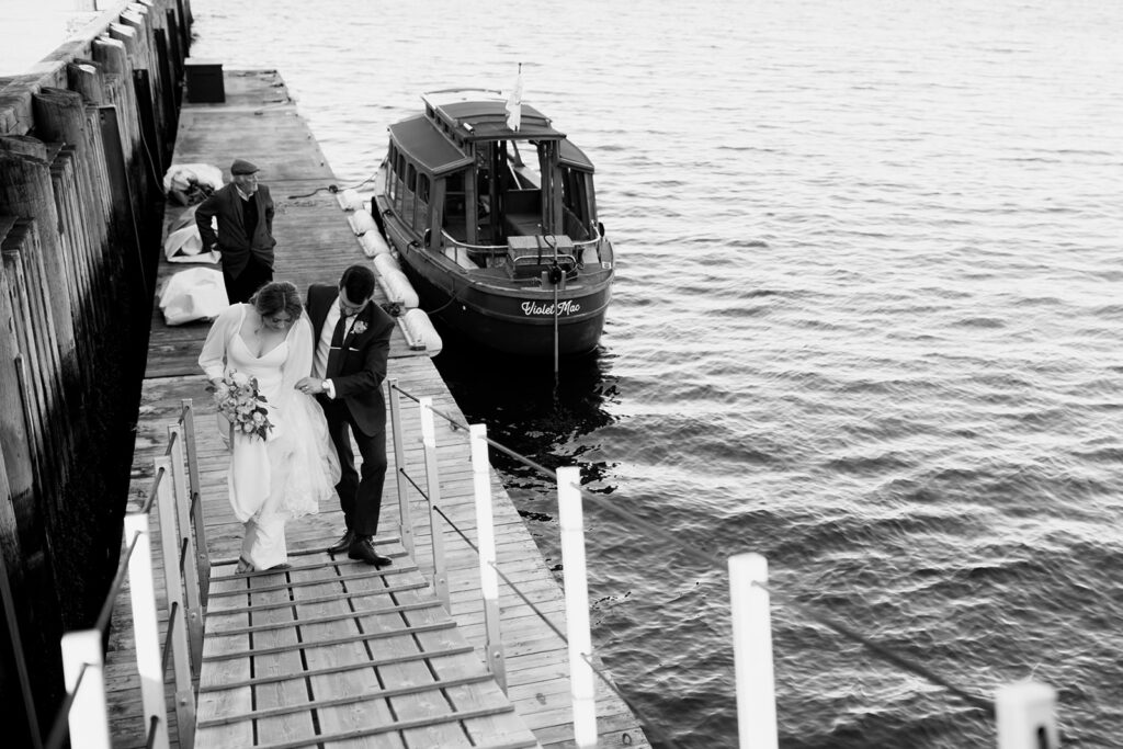 Wedding couple walking down dock outside Muir Hotel in Halifax, Nova Scotia