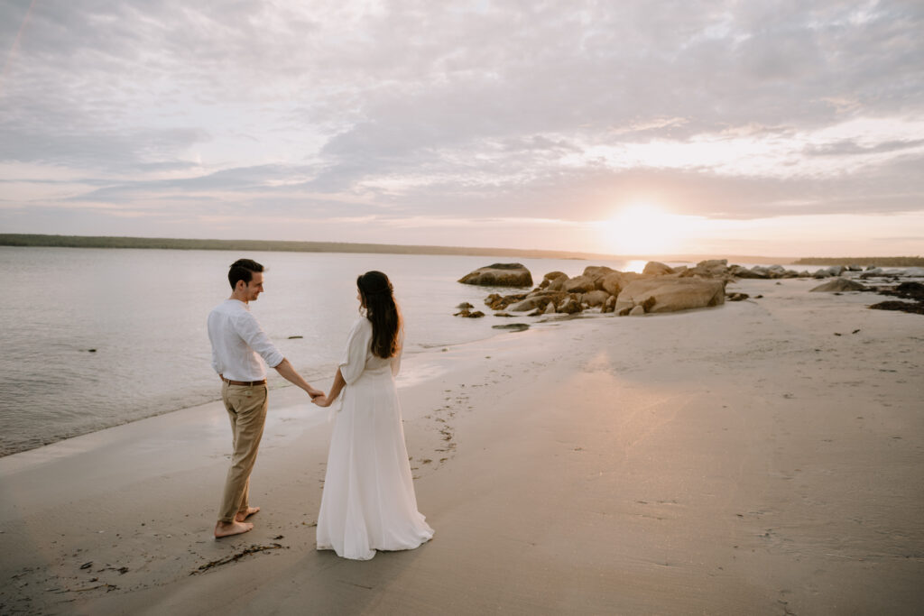 Intimate moment of wedding couple holding hands at sunset. Photographed by Nova Scotia Wedding Photographer.