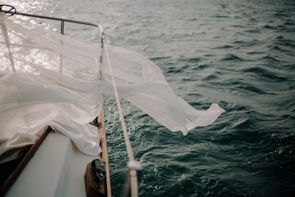 Bride's veil blowing over edge of sailboat at Halifax sailboat elopement