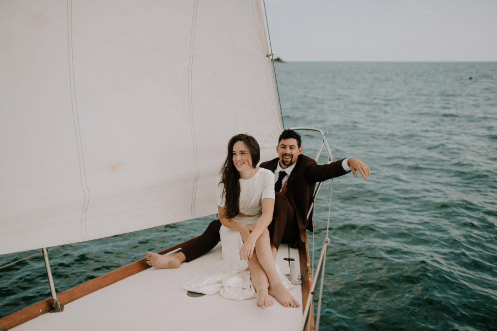 Wedding couple smiling on sailboat after intimate East Coast elopement. Shot by Nova Scotia Wedding Photographer.