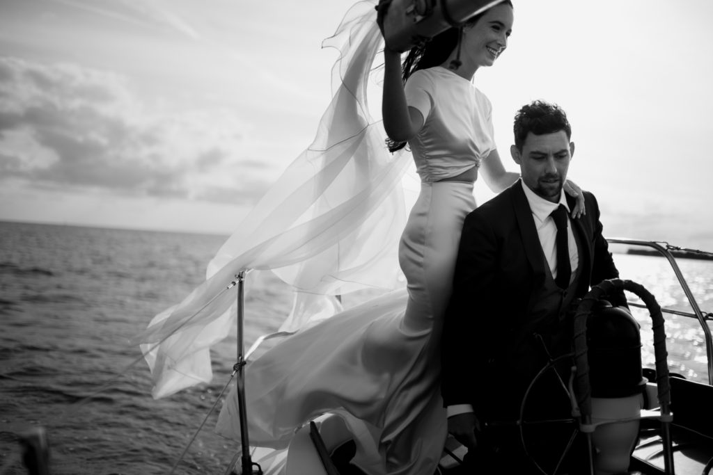 Candid moment of wedding couple sailing the Atlantic Ocean by Nova Scotia wedding photographer