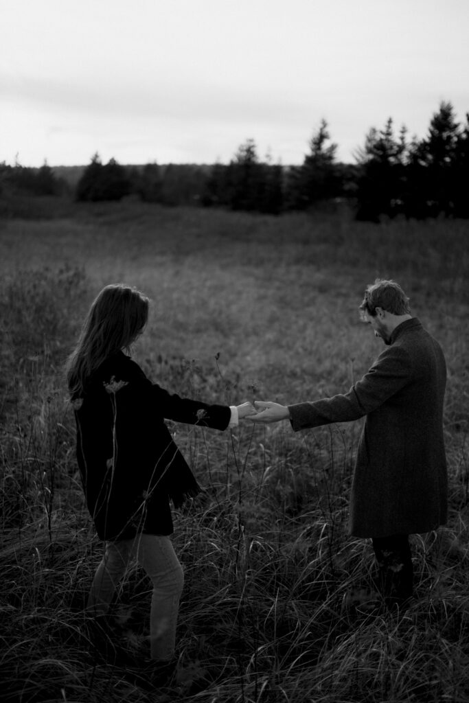 Couple holding hands in grass on Nova Scotian Beach